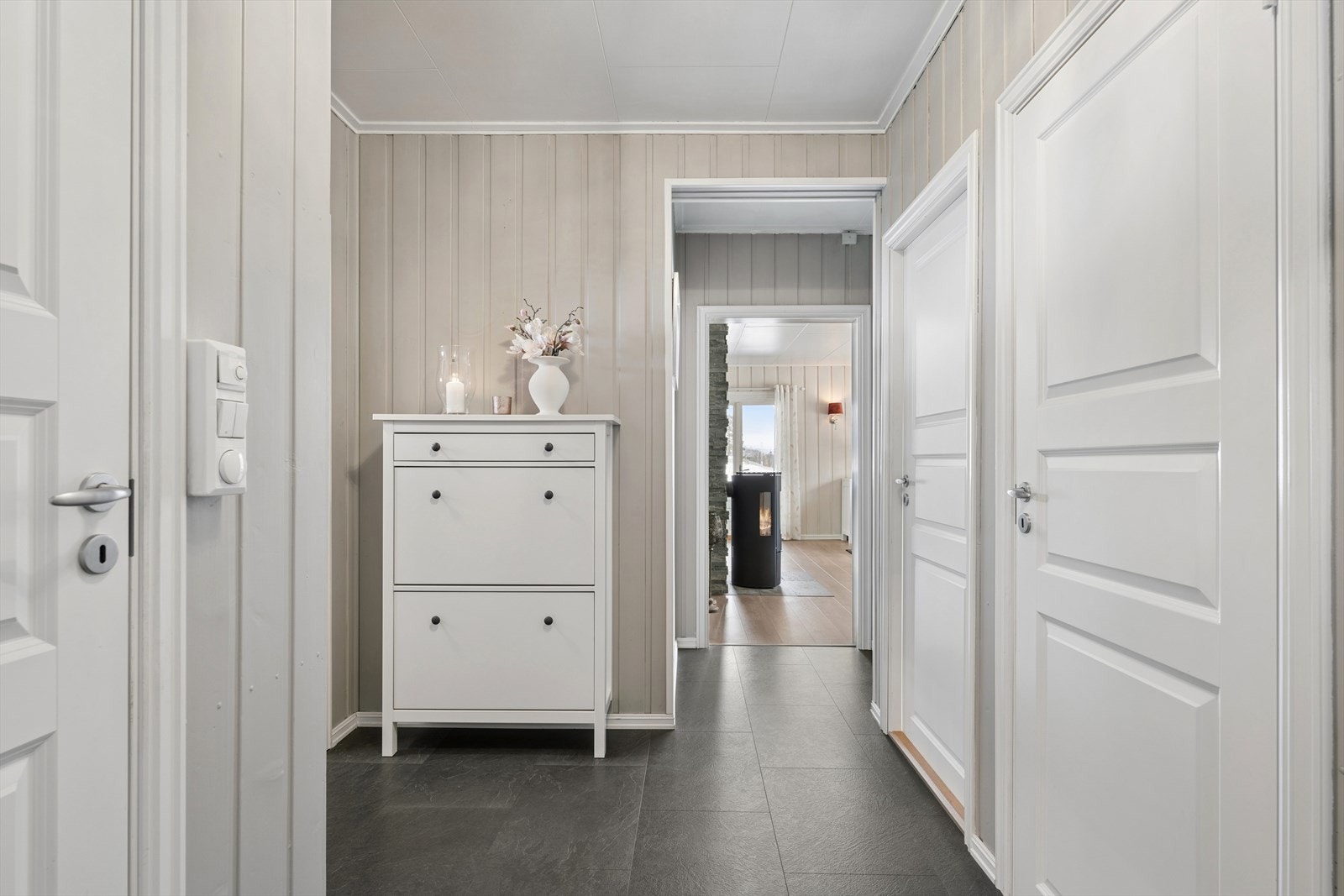 Fra gangen er det en åpen siktlinje inn mot stuen og ildstedet. Galleribilde