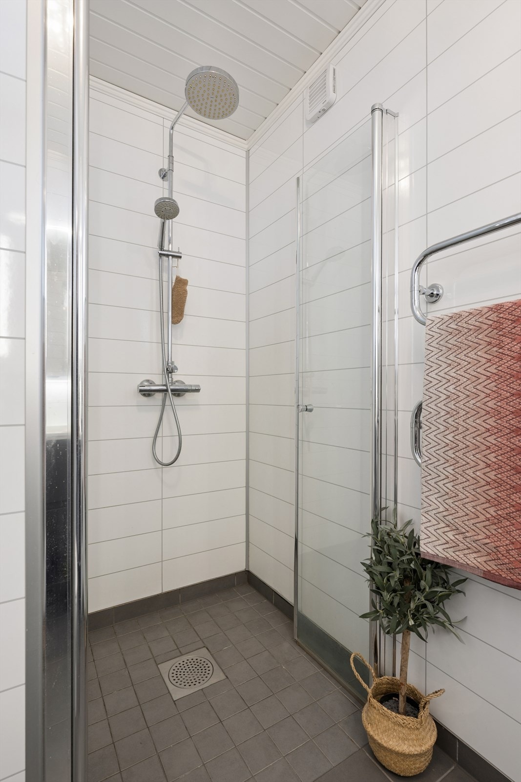 Her er det flislagt gulv med elektriske varmekabler og en praktisk dusjnisje. Galleribilde