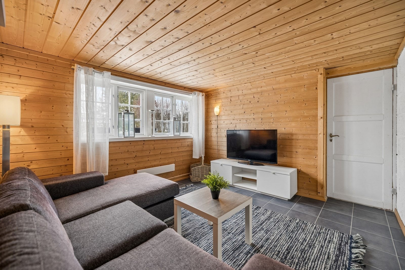 Oppholdsrom i kjeller med panelte vegger og lun atmosfære. Rommet er ikke bruksendret til varig opphold. Galleribilde