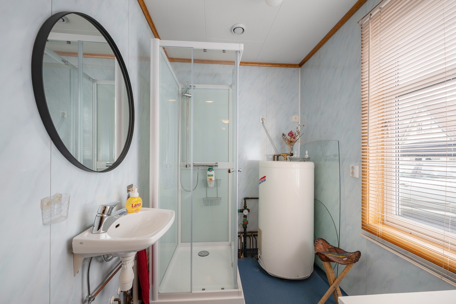 Praktisk vaskerom/teknisk rom med vinylbelegg på gulv med elektriske varmekabler. Rommet er utstyrt med servant, dusjkabinett og opplegg for vaskemaskin (avløp i gulv). Galleribilde