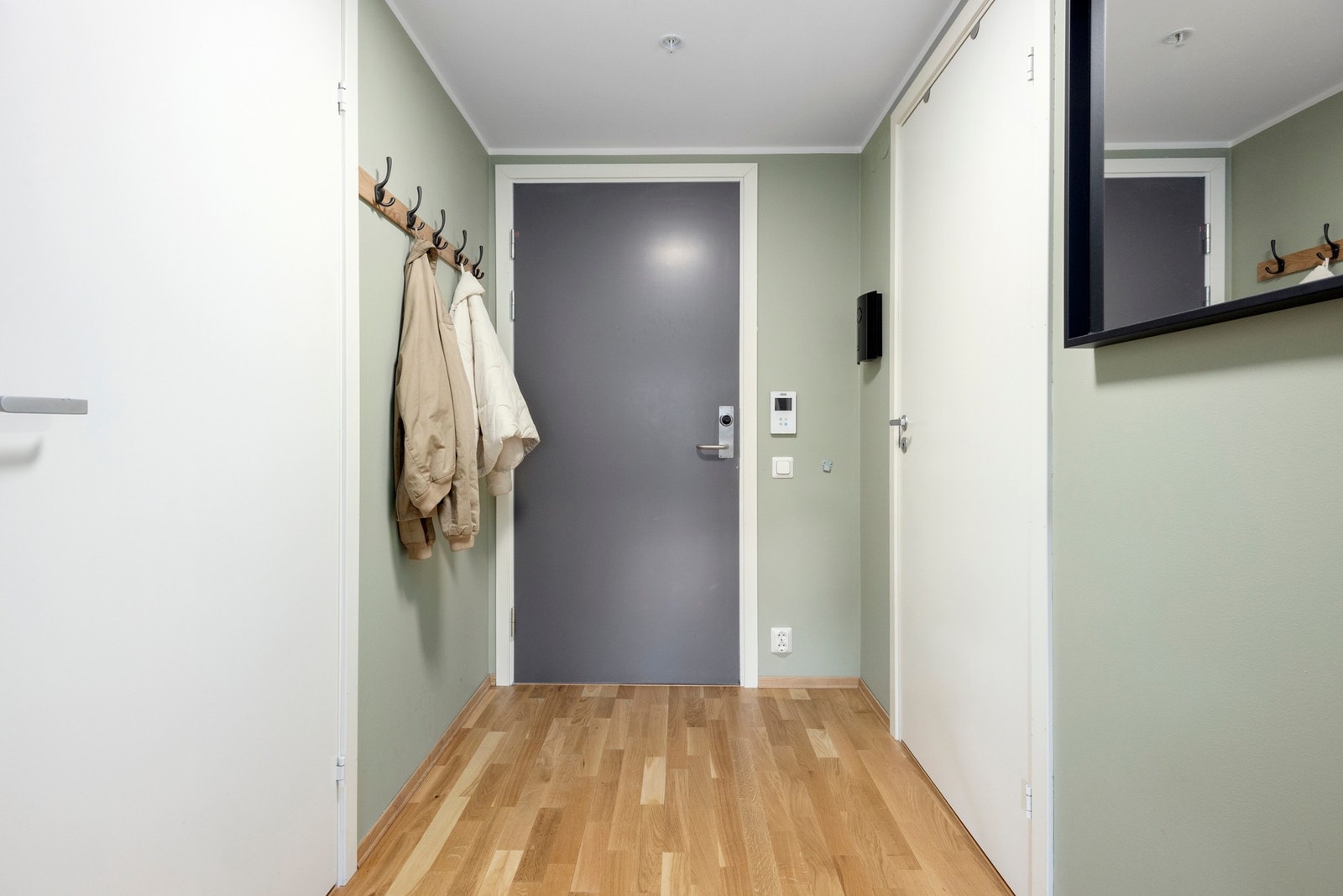 Leiligheten har en romslig entré med calling-anlegg og plass til yttertøy og sko Galleribilde