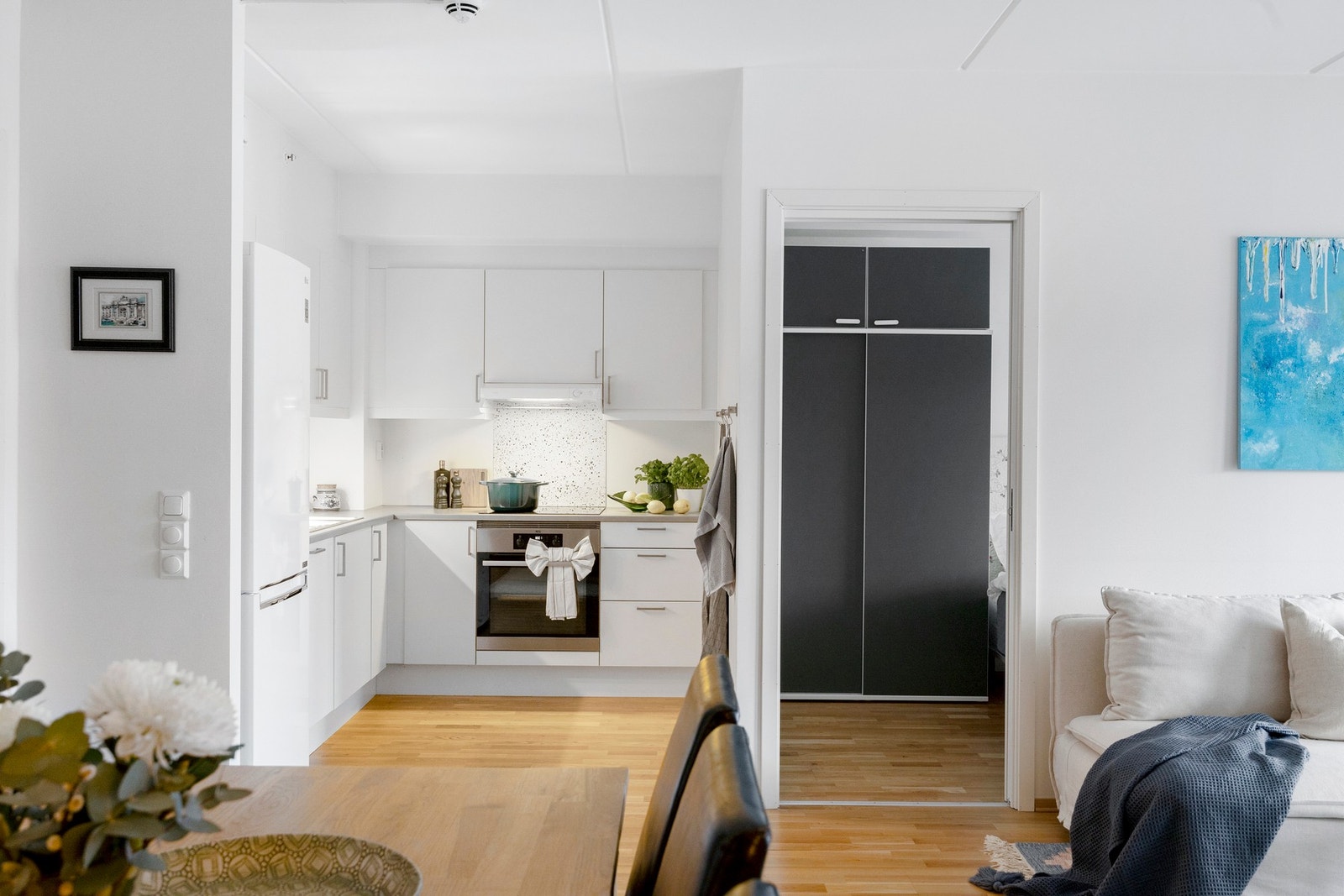 Sigdal kjøkkeninnredning med delvis integrerte hvitevarer og frittstående kjøleskap Galleribilde