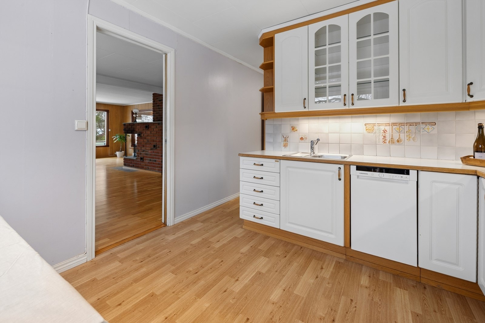 Kjøkkenet har innredning med profilerte fronter. Benkeplaten er av laminat. Det er kjøleskap, oppvaskmaskin, platetopp og stekeovn. Enkelte bruks- og slitasjemerker er observert. Det er kjøkkenventilator med avtrekk ut. Galleribilde