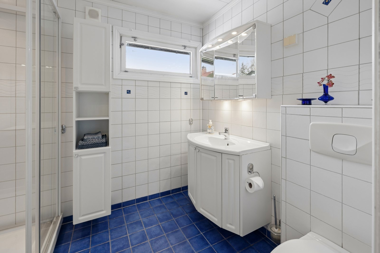 Rommet har innredning med nedfelt servant, veggmontert toalett og dusjkabinett. Det er mekanisk avtrekk. Galleribilde