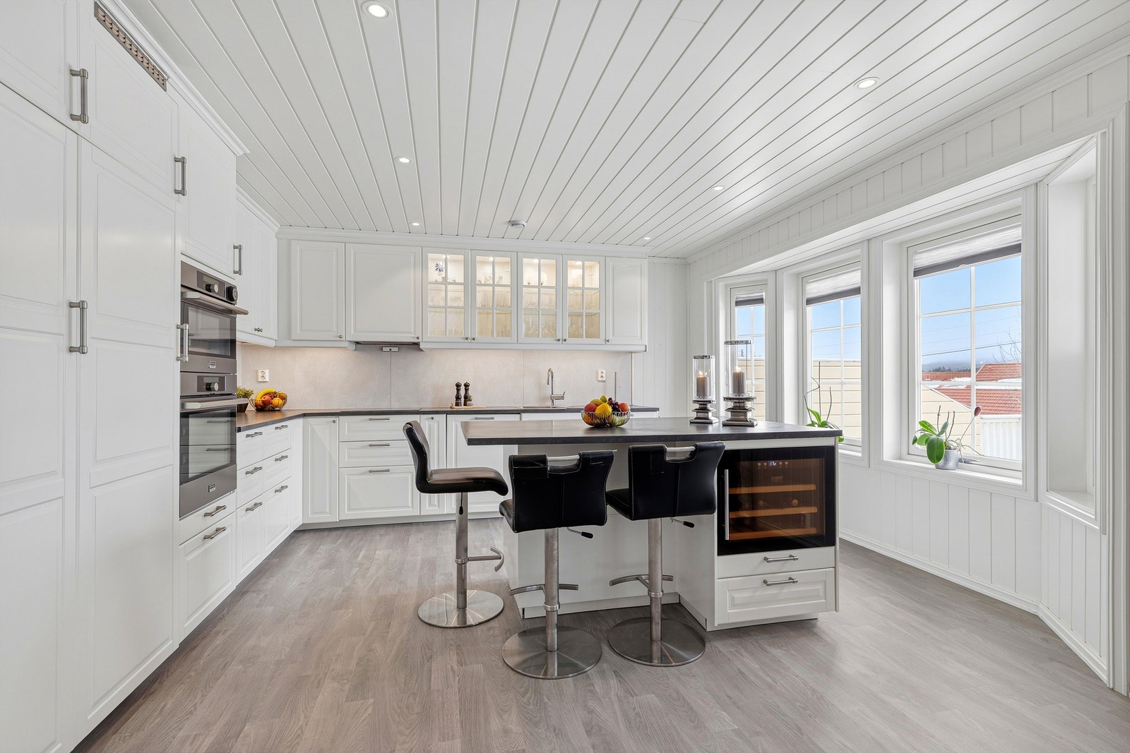 Nydelig kjøkken med masse lagringsplass og fin løsning med praktisk kjøkkenøy som også kan brukes til koselige morgenfrokoster Galleribilde