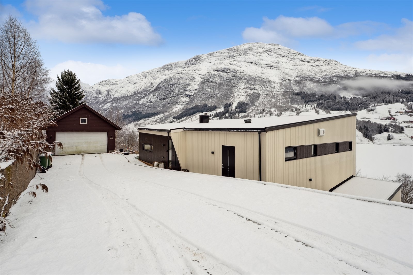 Gode parkeringstilhøve i garasje og elles på romsleg tunområde. Ein har òg bod med god lagringsplass i tilknytning til garasjen. Galleribilde