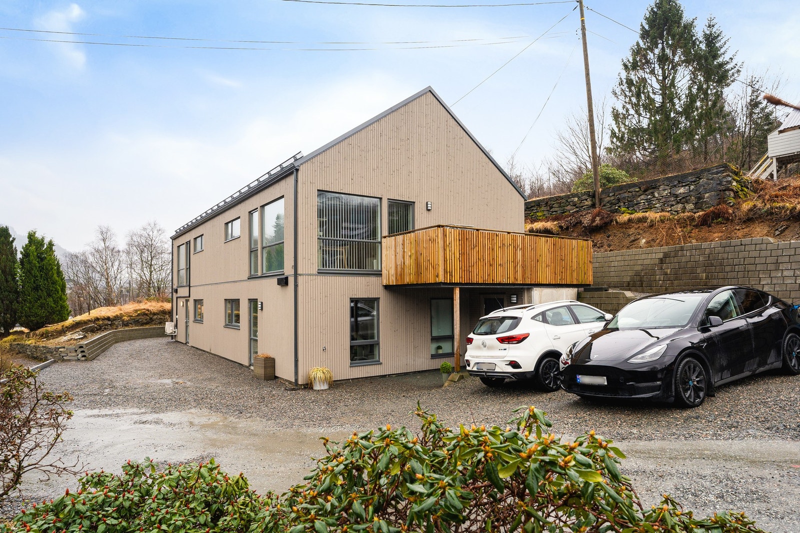 Området er i en etableringsfase og veien foran huset vil bli asfaltert i nær fremtid. Bak parkeringsplassen er veien opp til inngangsdøren bak huset. Galleribilde