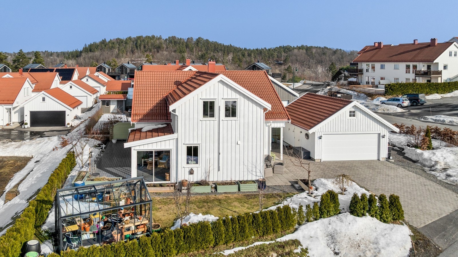 Rundt bebyggelsen er tomten opparbeidet med fin hage med plen, terrasse, hekk og noe prydbusker samt trær, stor terrasse mot vest og nord, drivhus og en hyggelig skjermet sommerstue . Galleribilde