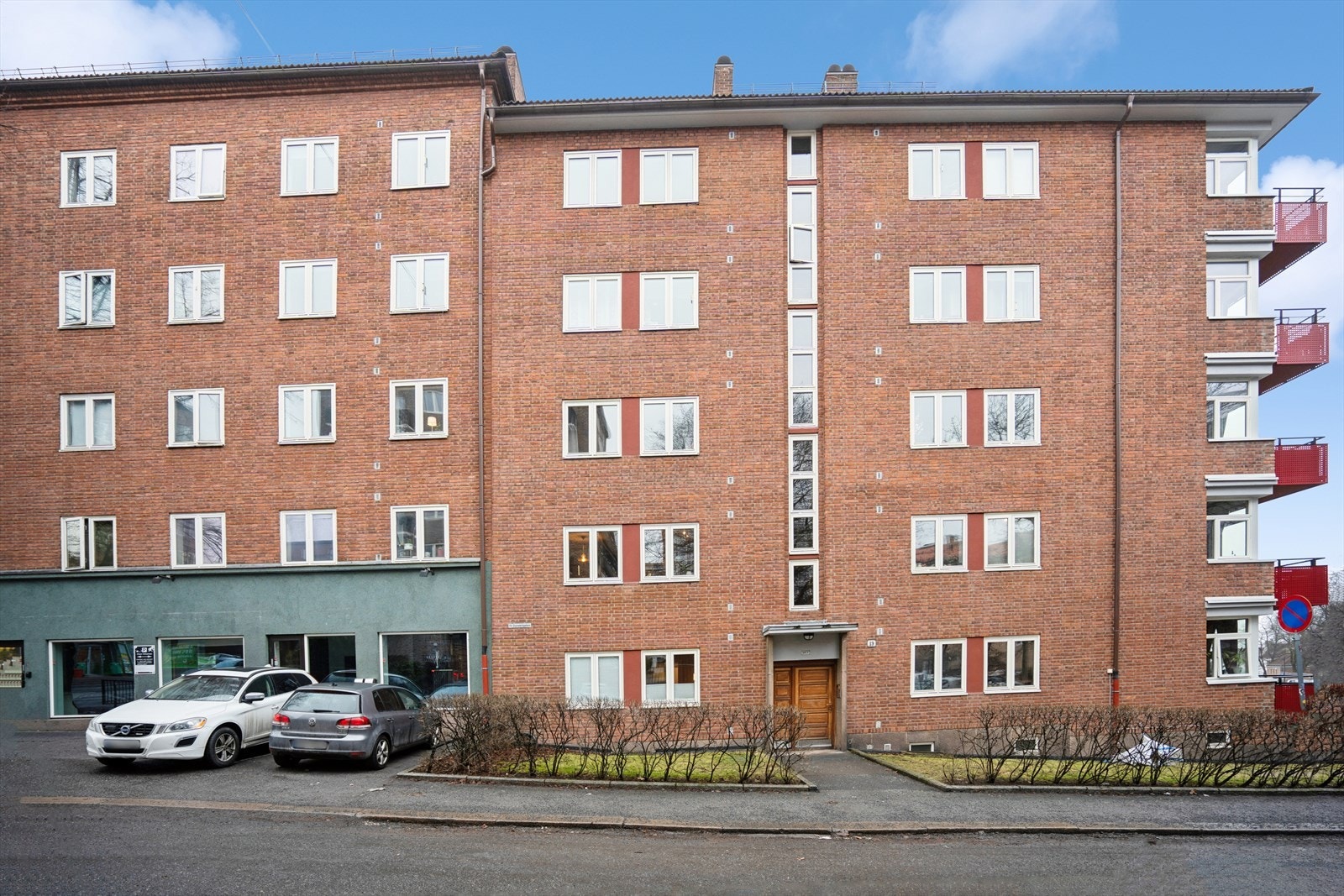 Man har parkeringskort til å parkere foran den grønne delen av bygget nede til venstre. Galleribilde