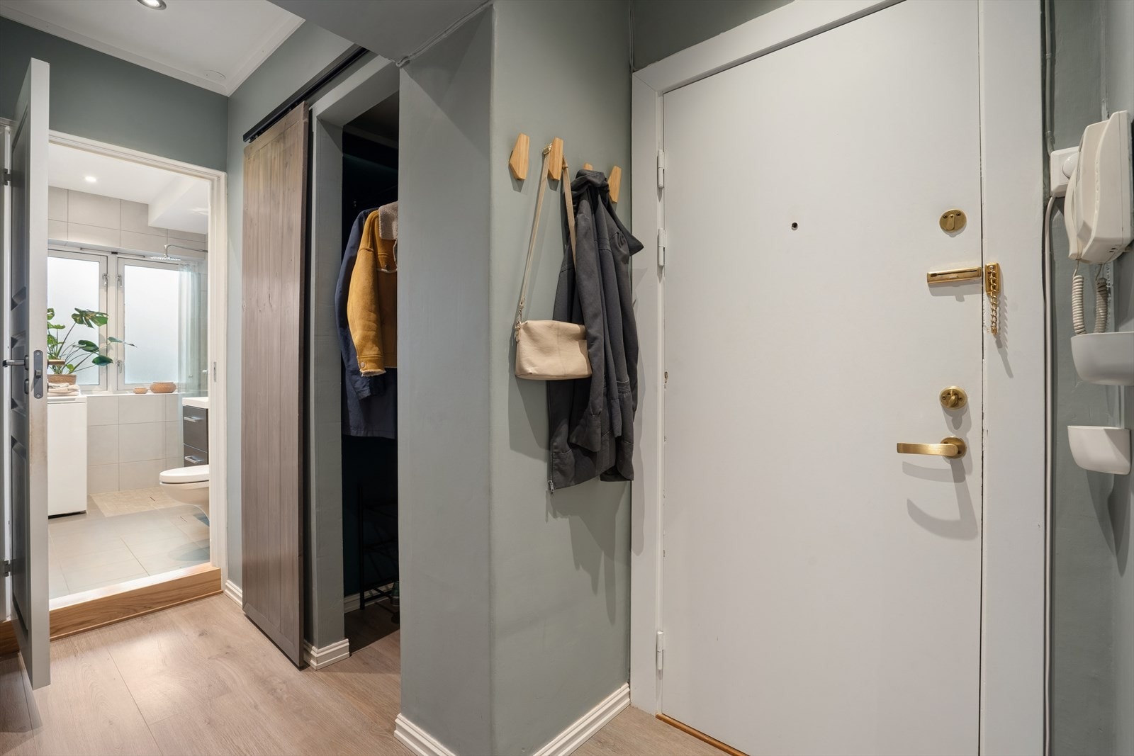 Lys entrè med skyvedørsgarderobe for yttertøy og sko. Galleribilde