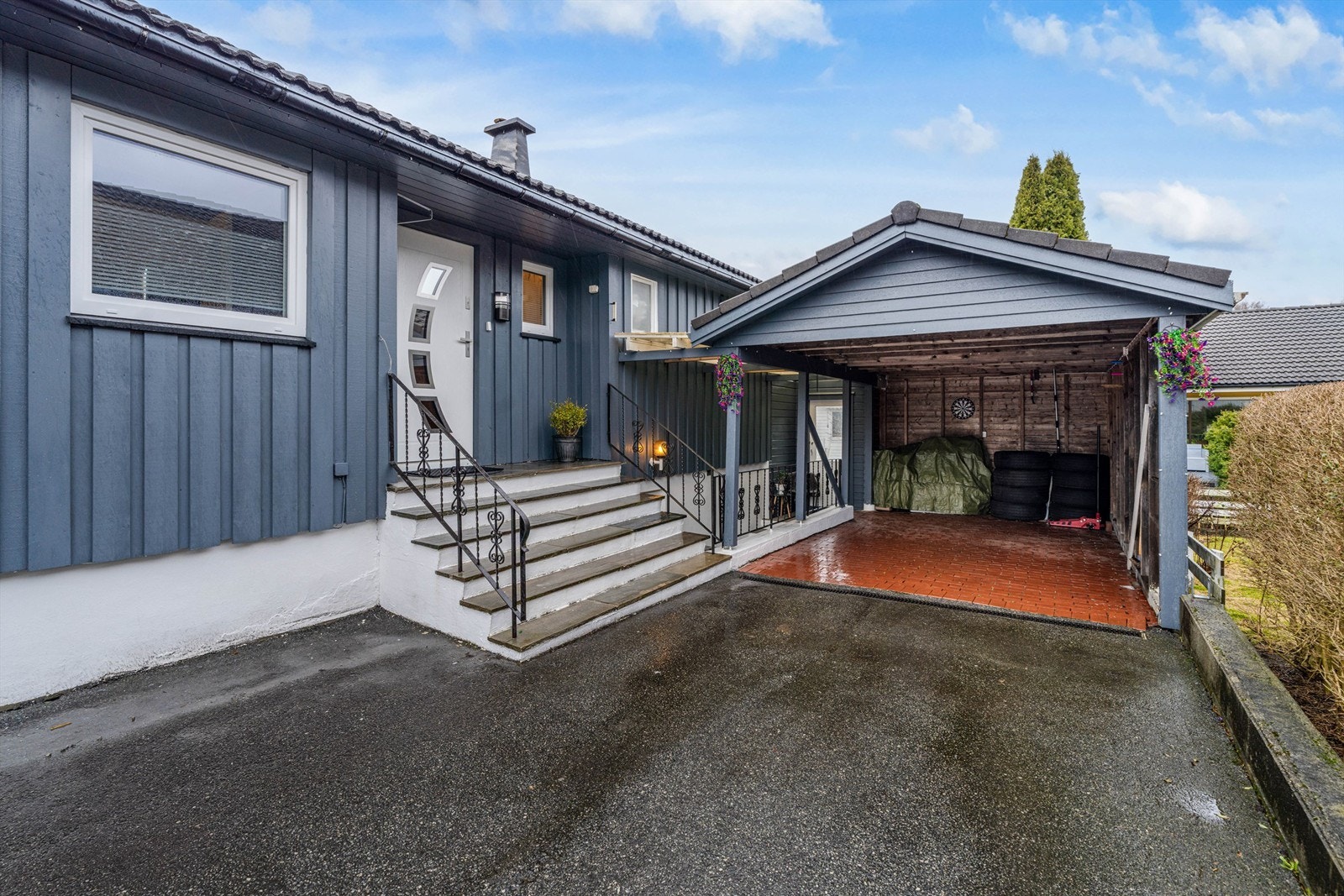 Asfaltert gårdsplass med carport og plass til parkering. Elbillader er installert. Galleribilde