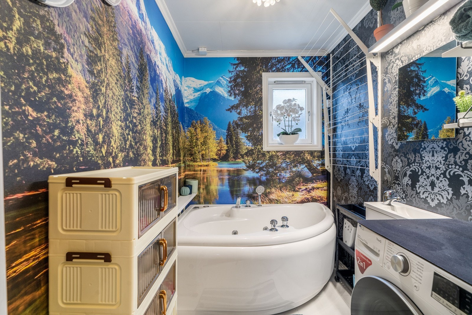 Praktisk kombinert bad og vaskerom med badekar, opplegg for vaskemaskin og varme i det flislagte gulvet. Galleribilde