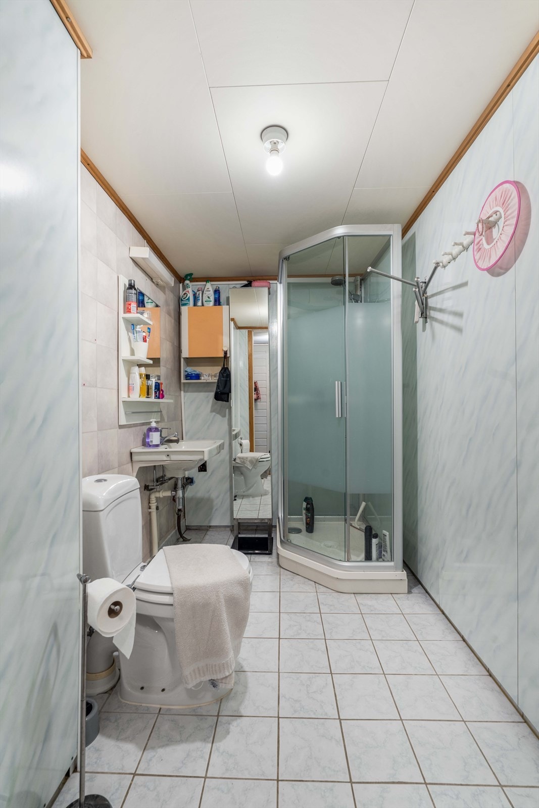 Badet i underetasjen har flislagt gulv med gulvvarme, dusjkabinett og baderomsplater på veggene. Rommet er godkjent som redskap/vaskerom. Galleribilde