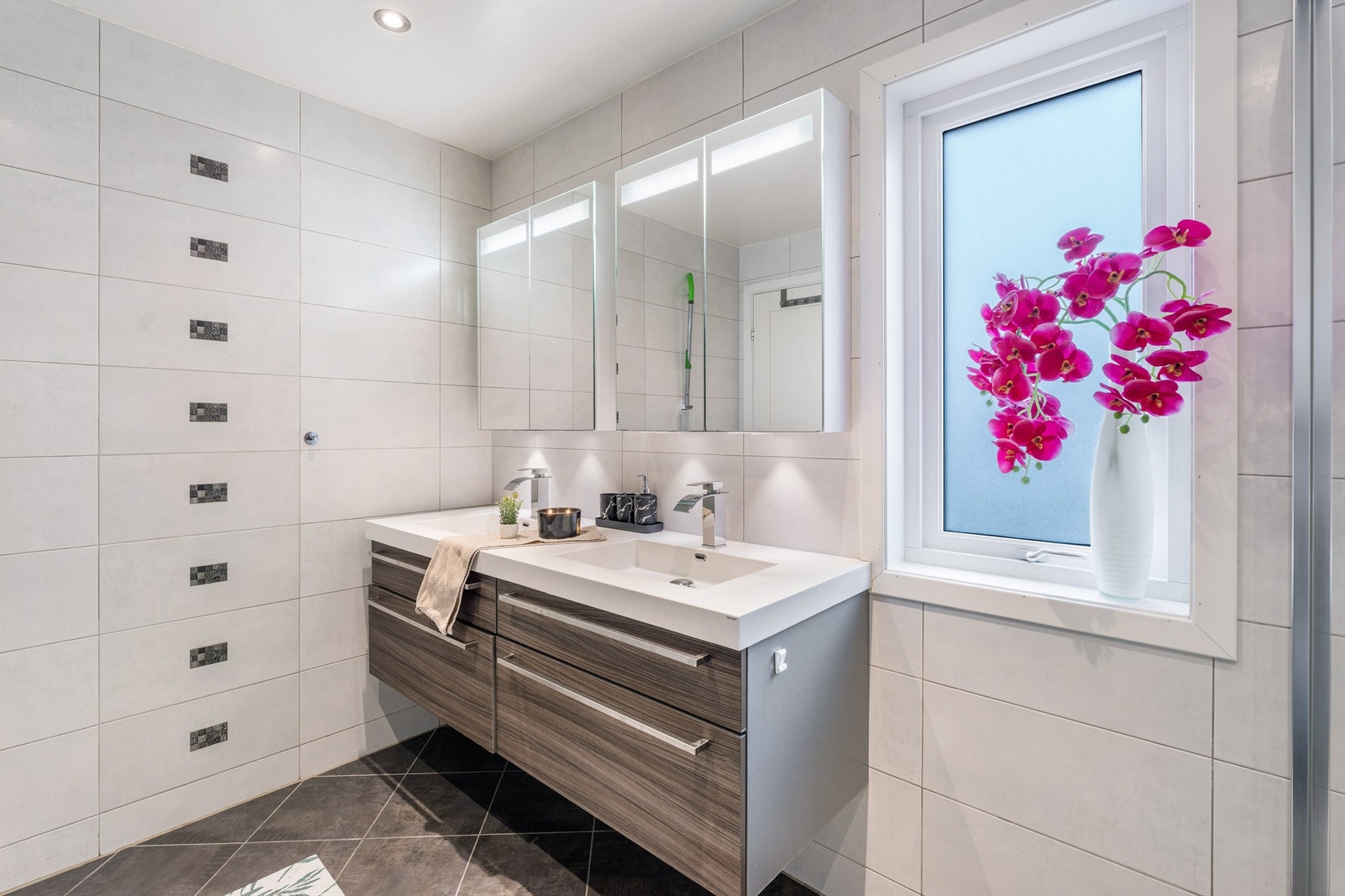 Baderomsinnredning med dobbel servant og speilskap med integrert belysning. Galleribilde