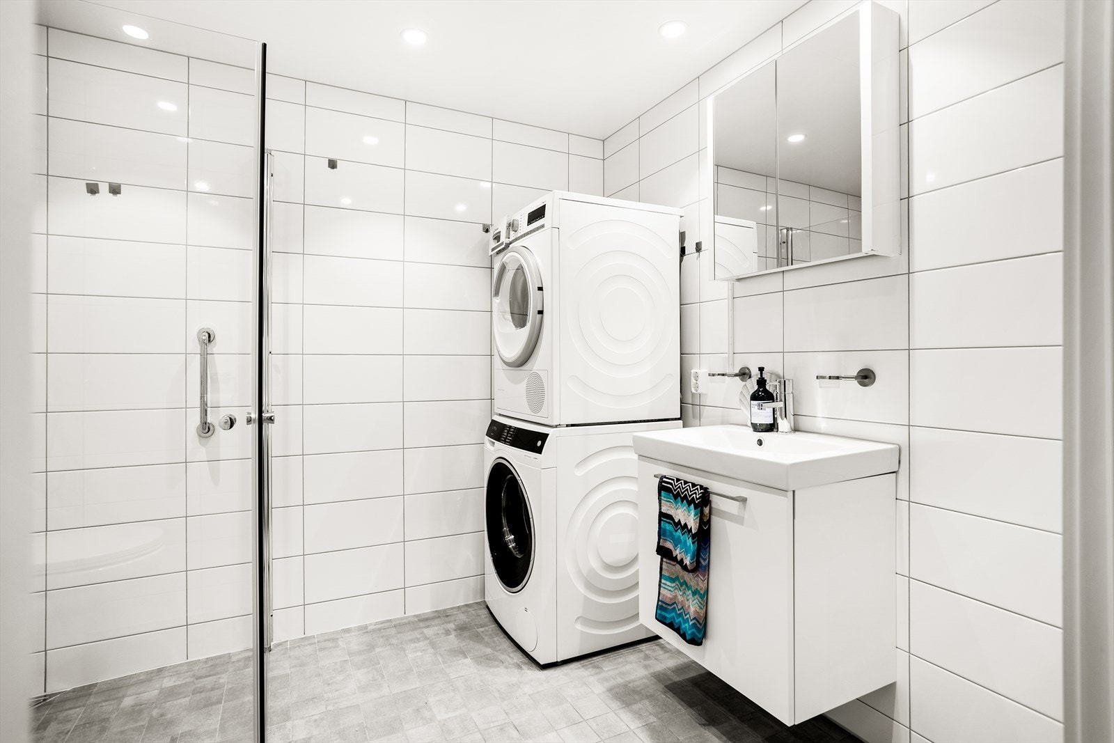 Kombinert bad og vaskerom med fliser på gulv og vegg. Galleribilde