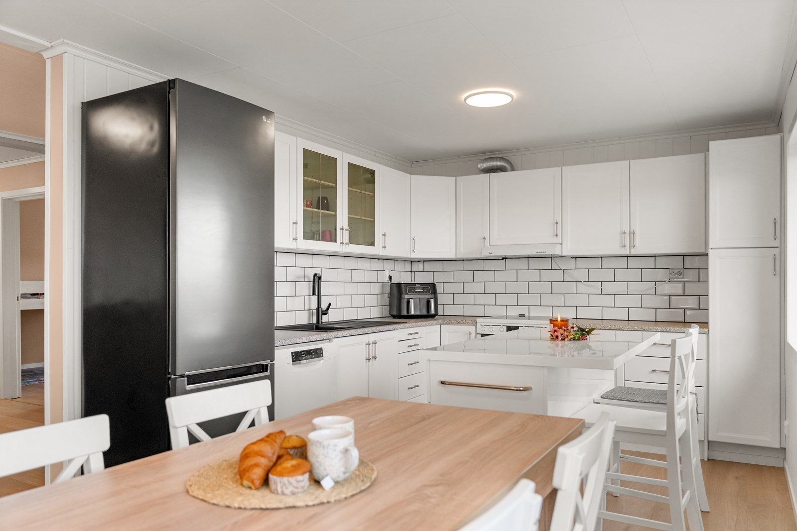 Pent kjøkken med fliser på vegg mellom kjøkkenbenk og overskap Galleribilde