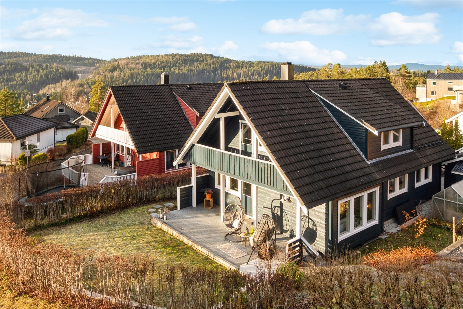 Hagen er flat og hyggelig. Huset er malt i en pen, mørk blåtone. Galleribilde