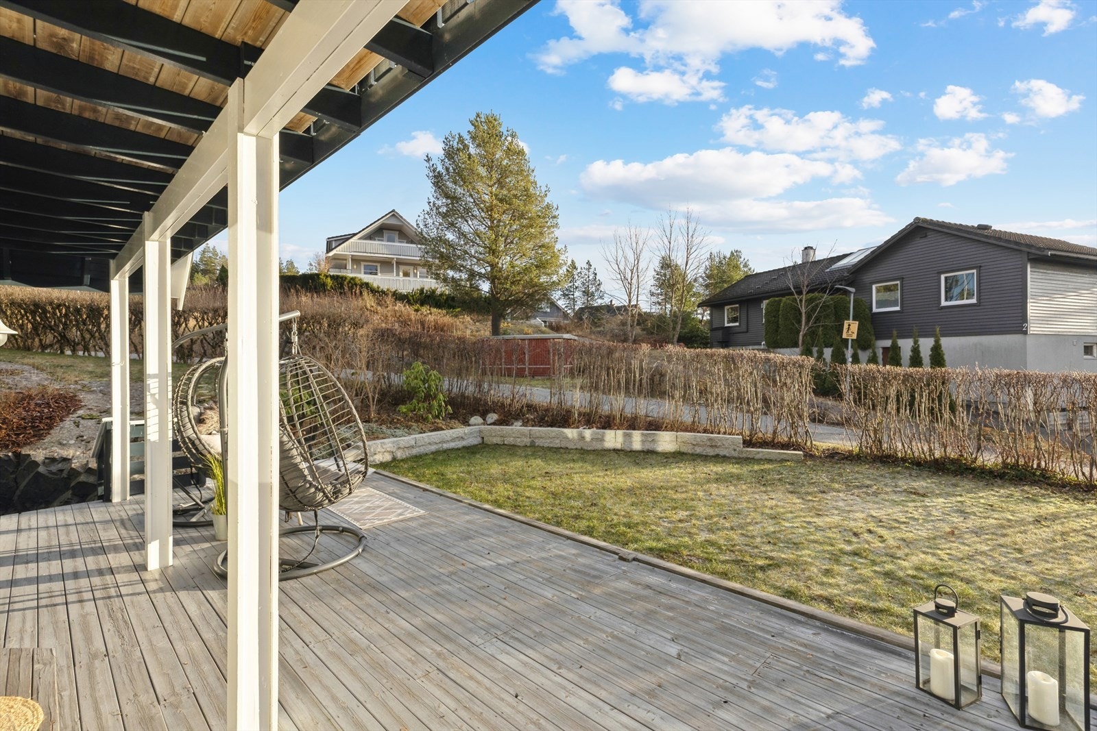 Frodig hekk (sommerstid) omkranser balkongen og skaper en lun, privat sommerplass. Galleribilde