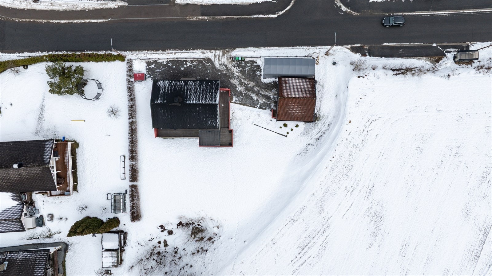 Tomten er opparbeidet med plen og en romslig, gruset gårdsplass. Galleribilde