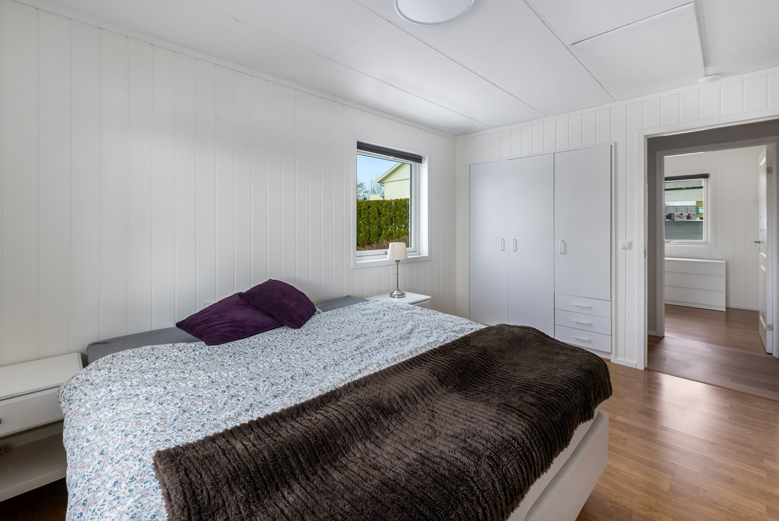 Hovedsoverommet er luftig med lysmalt panel, laminat på gulv og plassbygget garderobe. Galleribilde