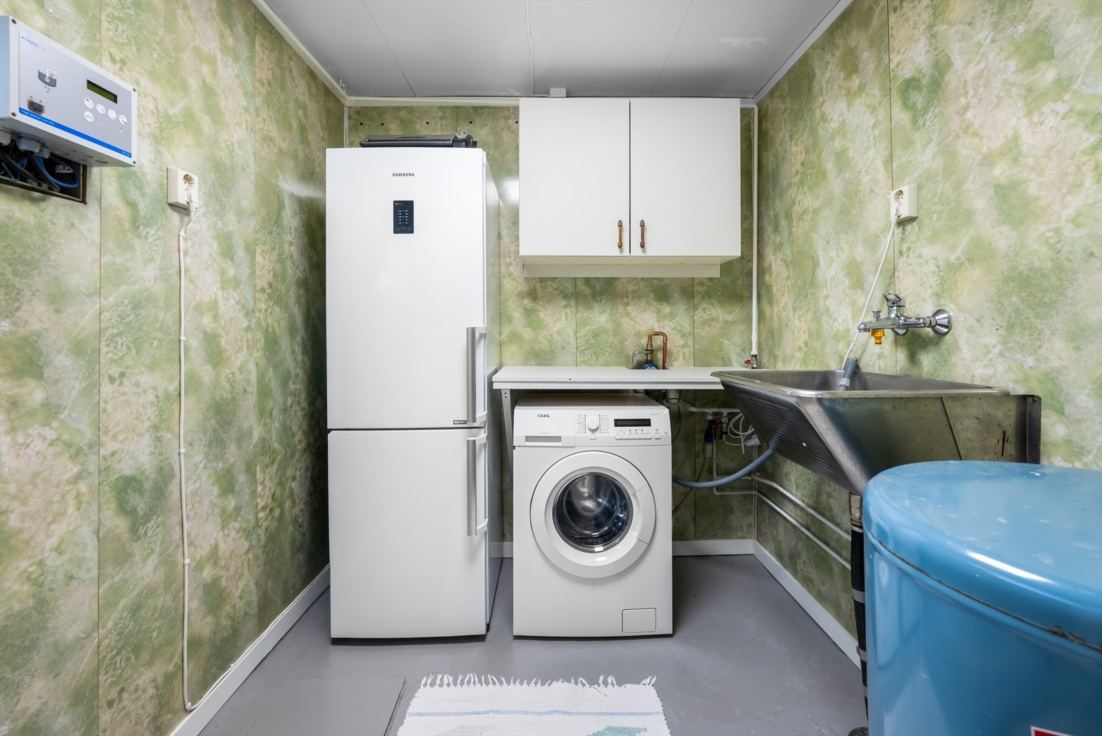 Praktisk vaskerom med våtromsplater på vegg og opplegg for vaskemaskin. Galleribilde