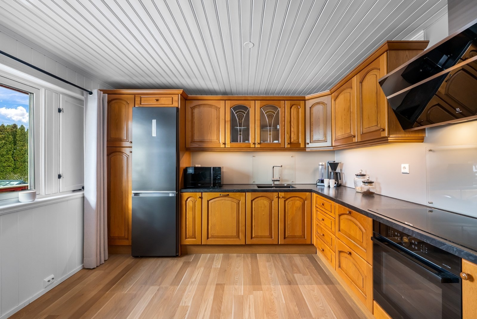 Innredningen har profilerte fronter, laminat benkeplate og belysning under overskap. Galleribilde