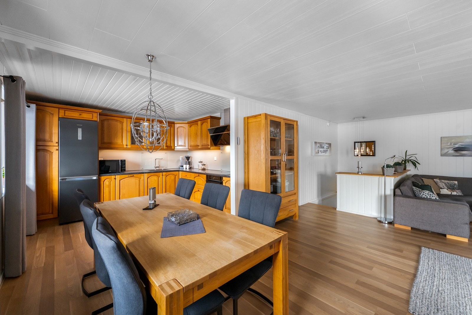 Detaljer som vitrineskap og integrerte hvitevarer som koketopp, stekeovn og oppvaskmaskin. Galleribilde