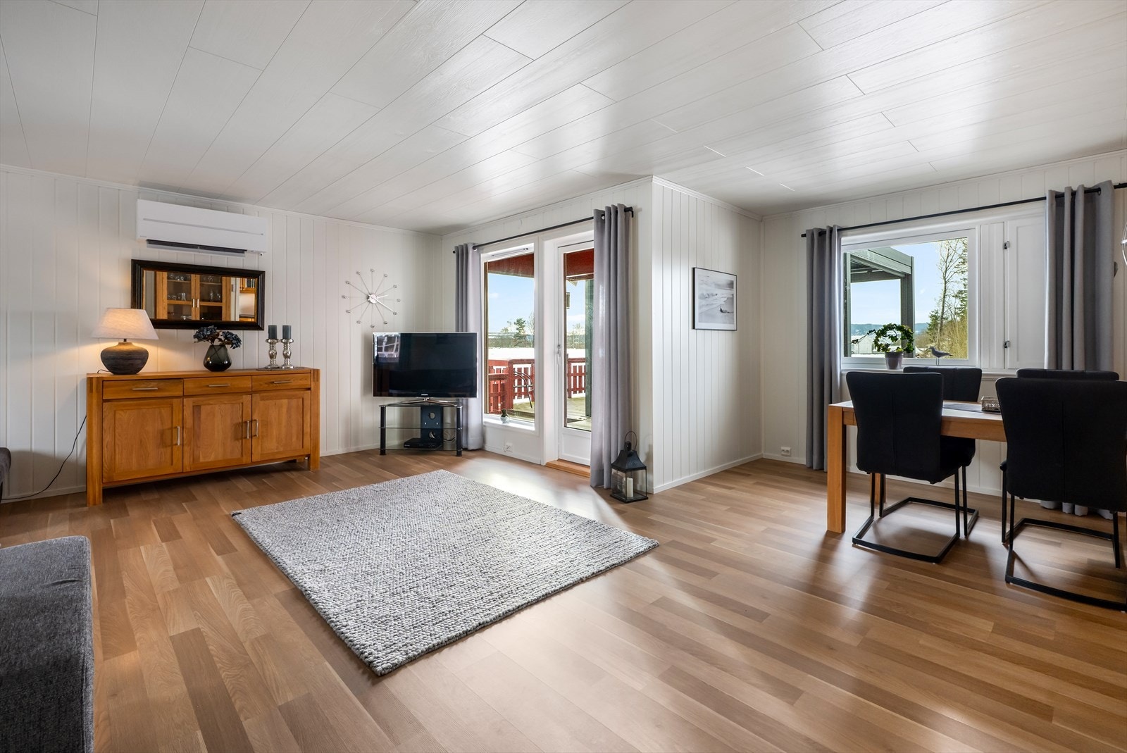 Innbydende stue med store vindusflater og utgang til terrasse. Galleribilde