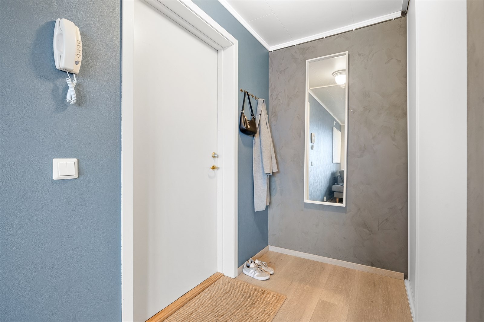 Her kommer man inn til en innbydende entré som utgjør hjemmets førsteinntrykk. Inngangspartiet er innredet med praktiske oppbevaringsmuligheter av klær og sko. Galleribilde