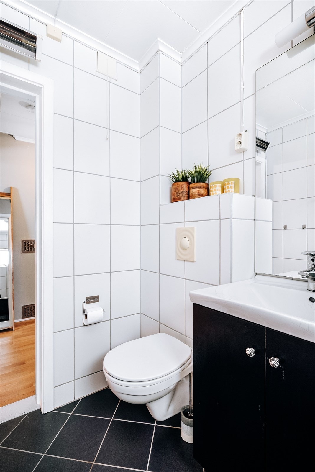 Badet har veggmontert toalett og baderomsinnredning med underskap og heldekkende servant. Speil, lys og elektrisk uttak på vegg over servanten. Galleribilde