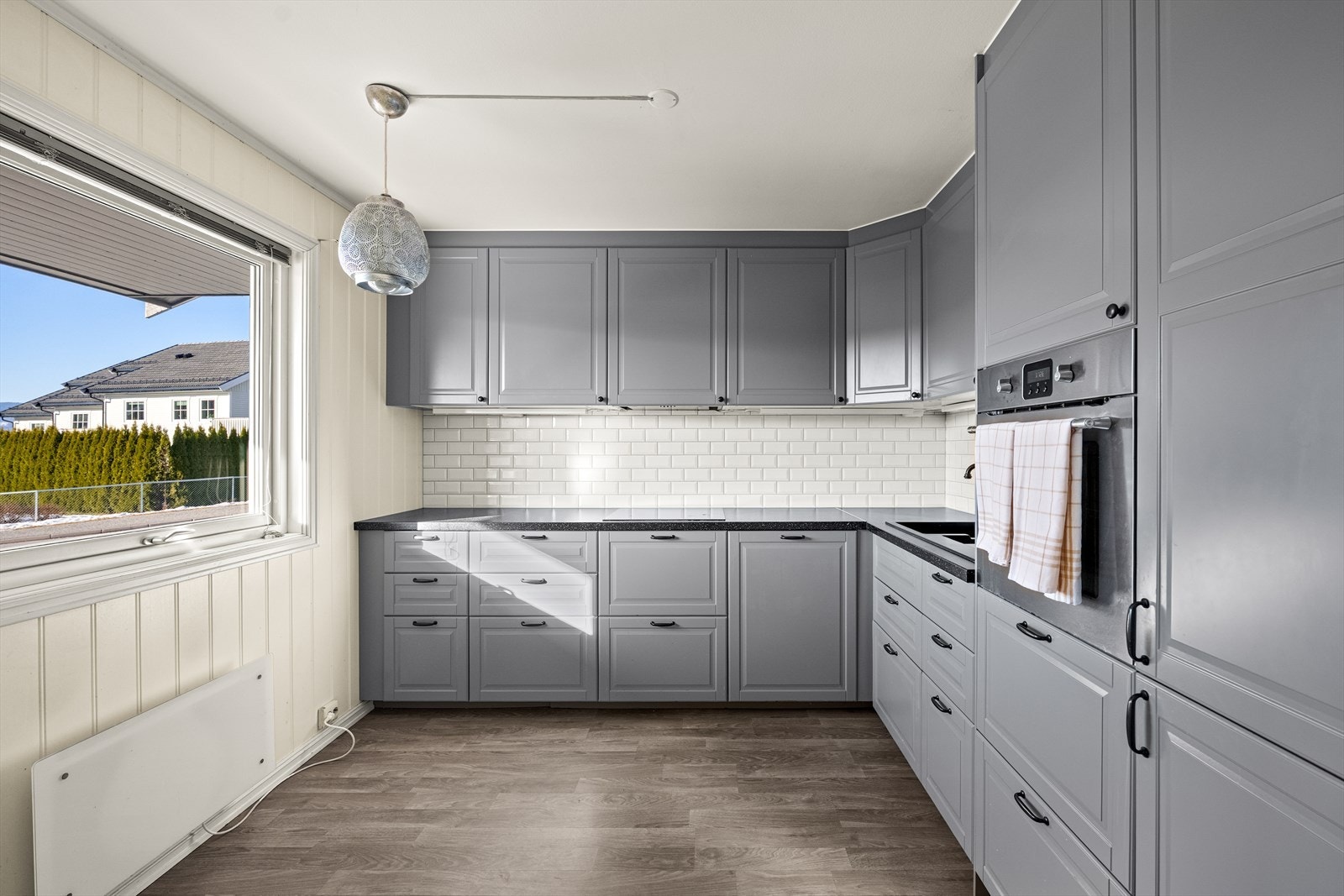 Kjøkkenet har innredning med profilerte fronter i en moderne fargepalett. Galleribilde