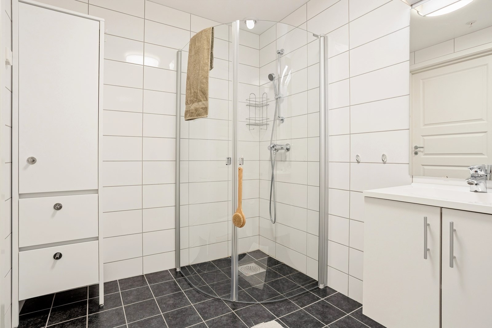 Baderommet er av god størrelse, innredet med dusjhjørne, servant med skap, speil med belysning m.m. Galleribilde