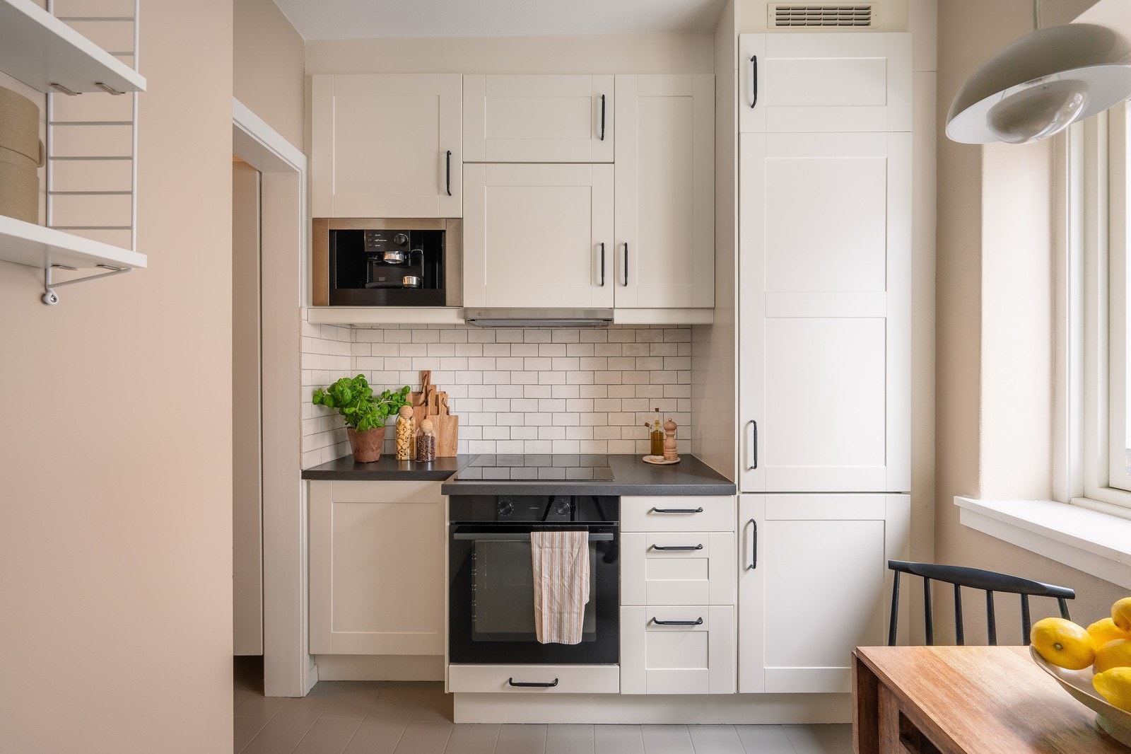 Innredningen har hvite fronter, laminatbenkeplate og en praktisk, sort oppvaskkum. Kjøkkenventilator med kullfilter og integrerte hvitevarer som ovn, platetopp, kjøl og frys. Galleribilde