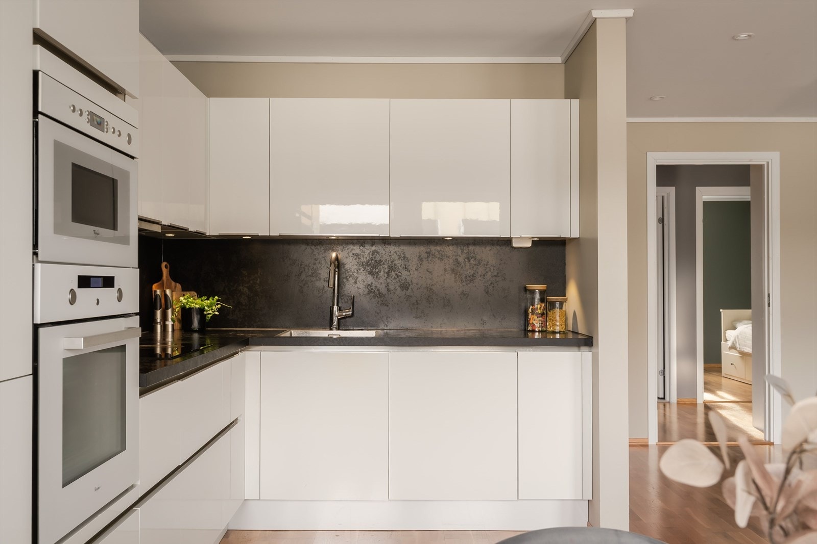 Kjøkkeninnredningen er holdt i en klassisk vinkelløsning med glatte og stilrene fronter. Galleribilde