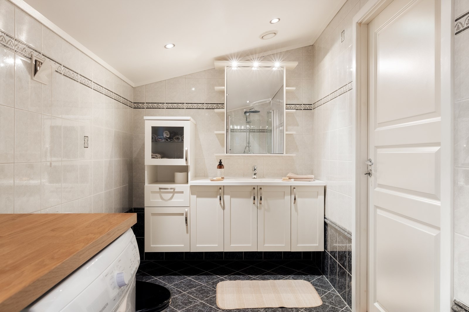 Badet måler 7 kvm. Veggene har fliser, taket er malt og gulvet er flislagt. Galleribilde