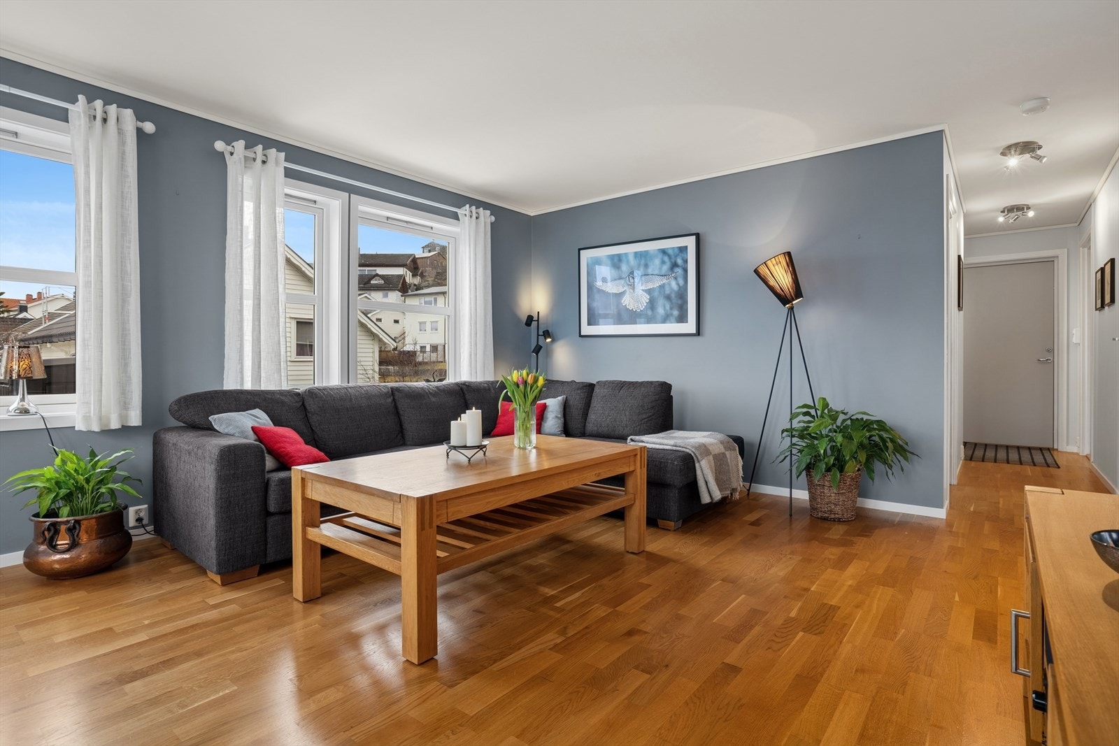 Videre inn kommer du til boligens sosiale sone som består av en luftig og åpen løsning mellom stue og kjøkken. De store vindusflatene langs to vegger gir flotte lysforhold gjennom hele dagen. Galleribilde