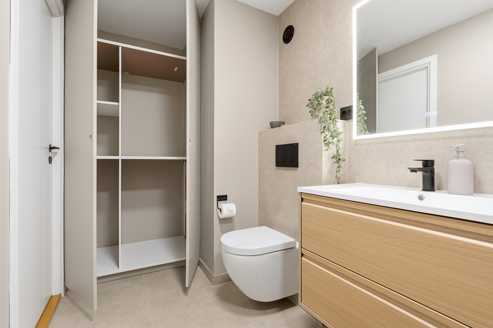 Bak skapdørene har du plass og opplegg for både vaskemaskin og tørketrommel, samt annen lagringsplass. Smart og lekkert utført! Galleribilde