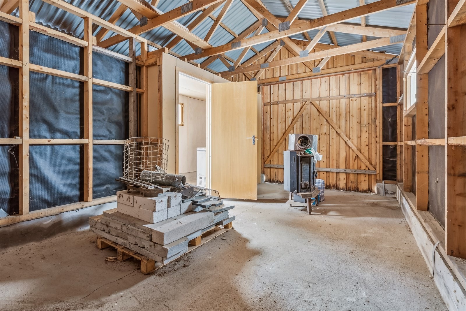 Den frittstående garasjen har støpt gulv, ringmur og en to-delt port i tre. Galleribilde