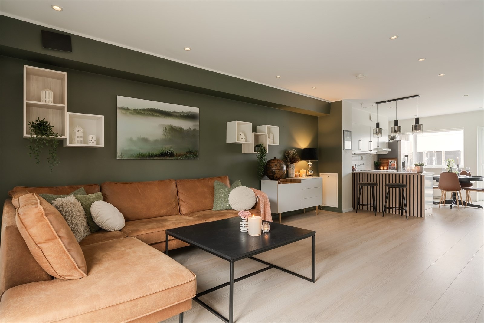 På gulvet er det lagt lyse gulvflater som bidrar til et moderne og lyst uttrykk, mens veggene er malt i en dyp grønnfarge som gir rommet karakter og en lun stemning. Galleribilde