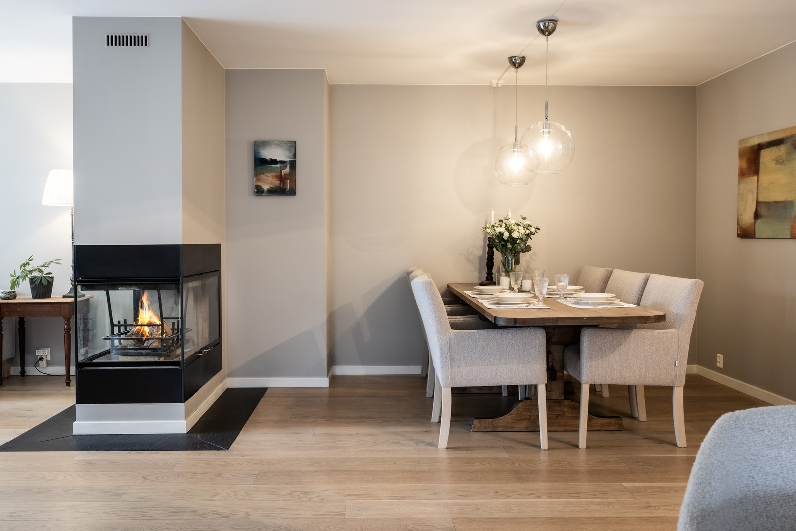 Nærheten til peis med glasspaneler på tre sider skaper en lun atmosfære i spisestuen. Galleribilde