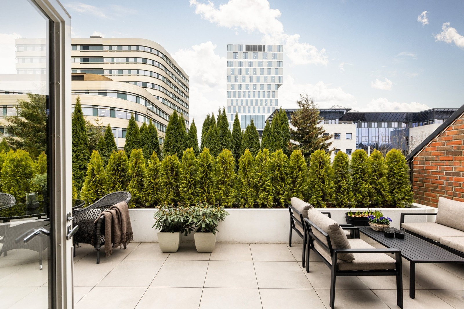 Kombinasjonen av eviggrønn vegetasjon i forgrunnen og moderne bebyggelse i bakgrunnen skaper et fint samspill mellom det skjermede og den sentrale beliggenheten. Galleribilde