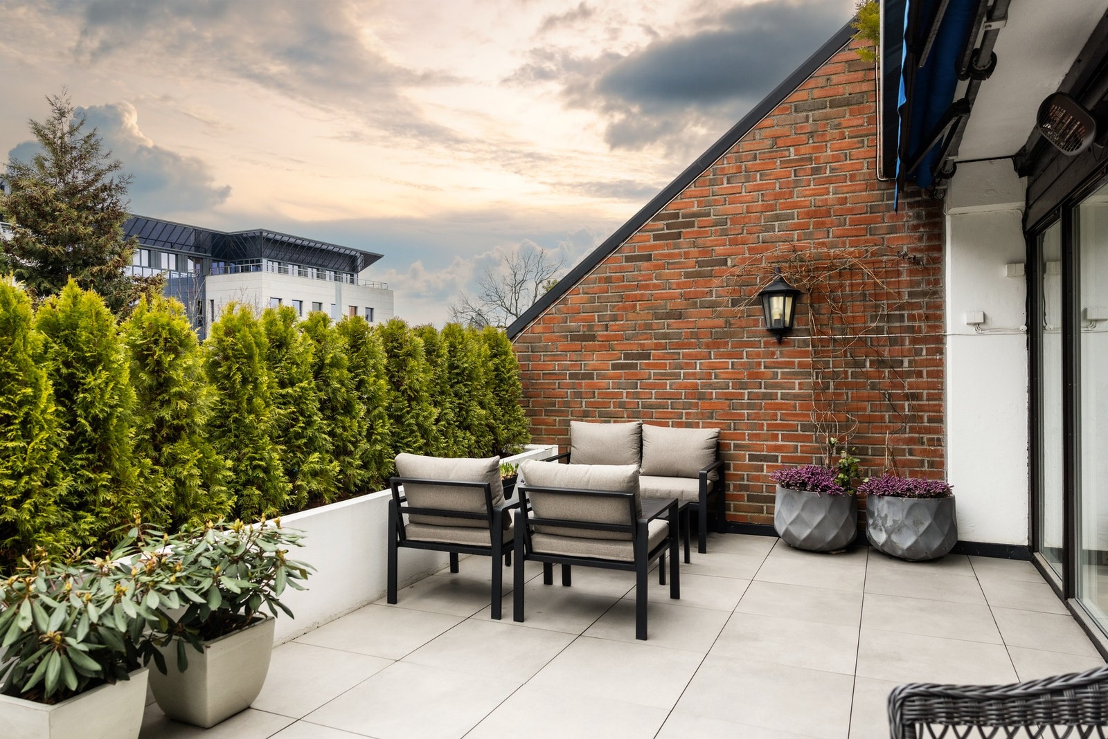 Uteplass har et fugefritt, flislagt gulv som gjør det enkelt å rengjøre og tørke.
Evig grønn beplantning gir et skjermet og koselig bomiljø. Galleribilde
