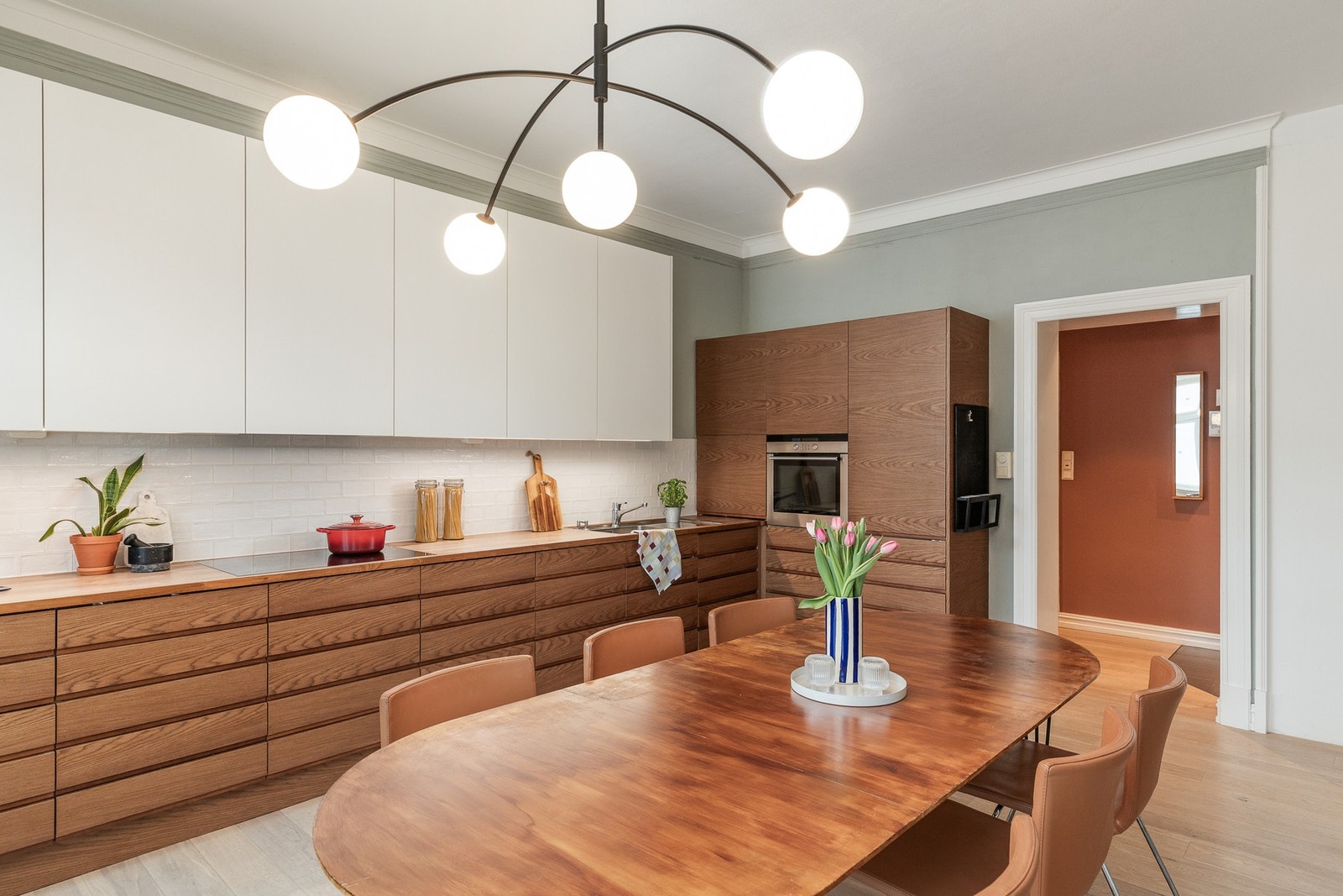 Delikat kjøkken med profilert og glatt kjøkkeninnredning med heltre benkeplate og integrerte hvitevarer. Galleribilde