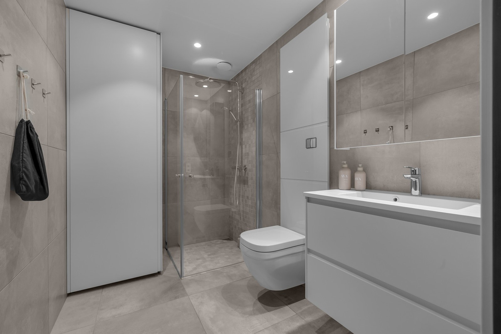 Den andre badet har fått en lun fargekombinasjon. Her er det også tilrettelagt for vaskemaskin og tørketrommel i et eget skap. Galleribilde