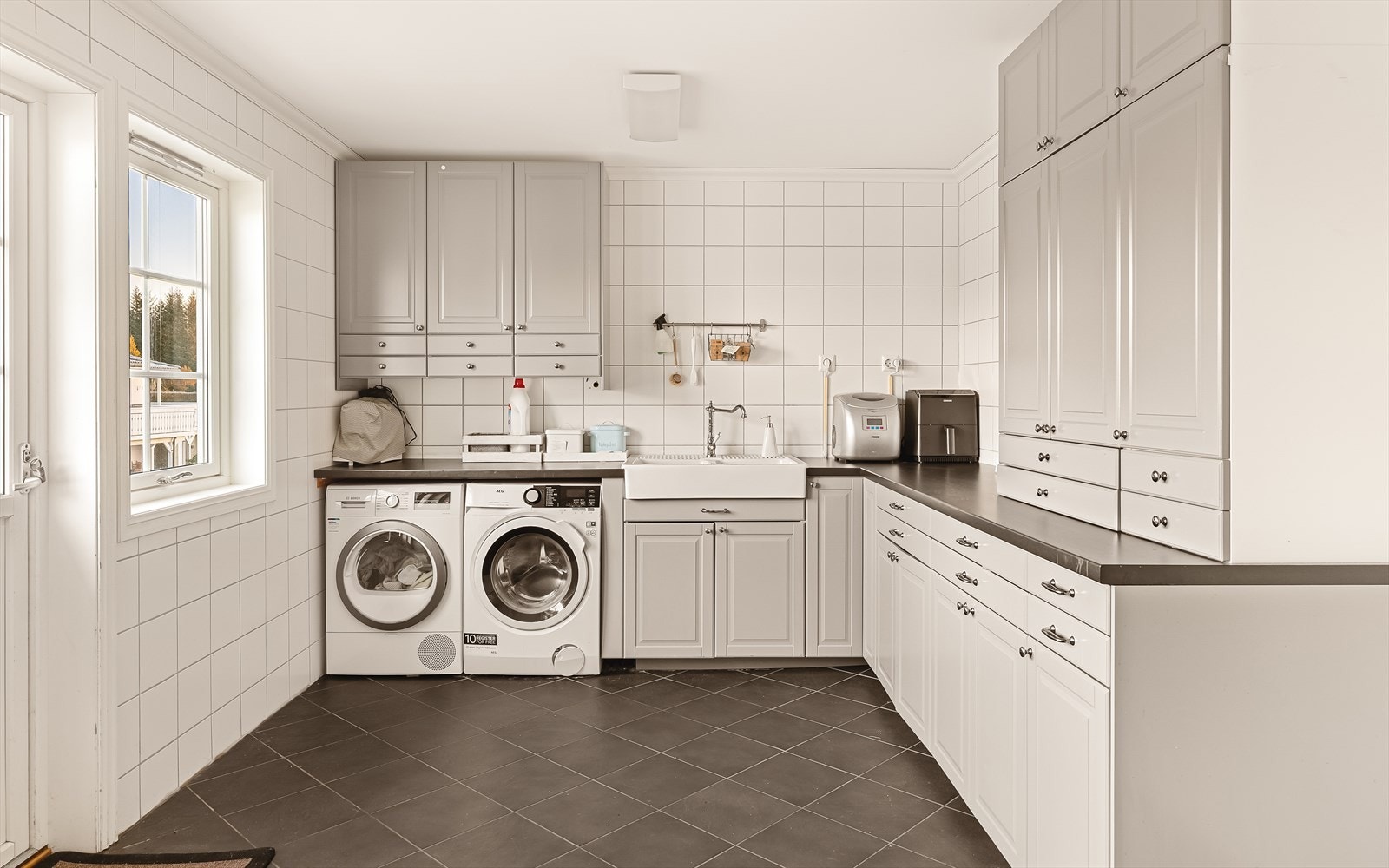 Stort, herlig vaskerom som gjør klesvasken litt hyggeligere. Pen innredning med god skap- og benkeplass. Innredet med utslagsvask, og egen ytterdør til gårdsplass. Galleribilde