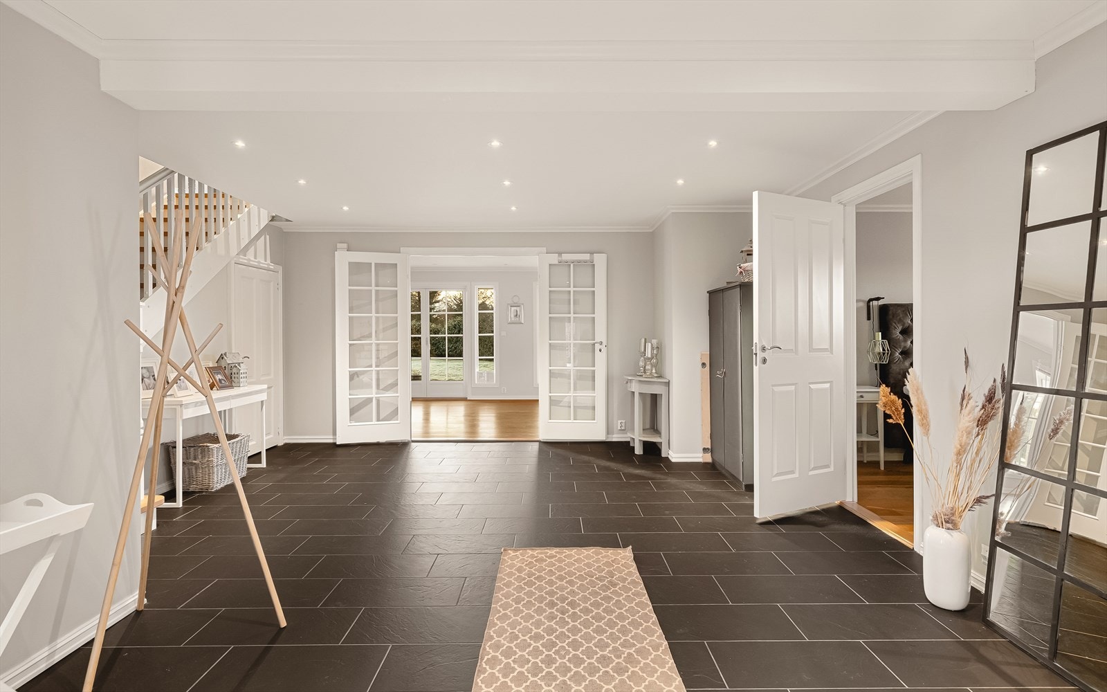 Hall er 33,2 m², og forgrener seg til de ulike rommene i etasjen, samt trapp opp til 2. etasje. Downlights i himling. Galleribilde