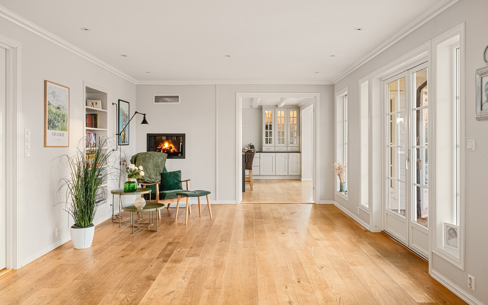 Doble dører inn til kjøkken gjør at man kan ha en åpen løsning, samtidig stenge igjen hvis man vil adskille rommene. Merk fin bokhylle integrert i vegg ved lesekrok. Galleribilde