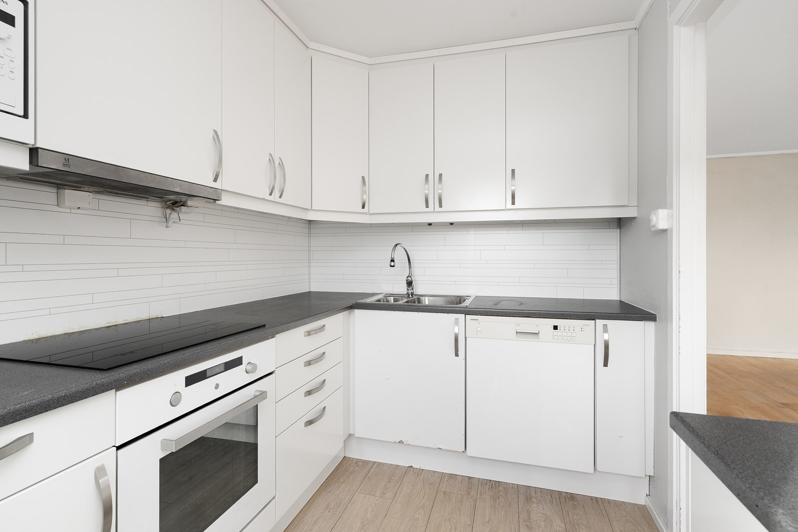 Kjøkkenet er på 6 m2 og har godt med oppbevaringsplass i takhøy innredning. Det er gode arbeidsflater på laminerte benkeplater, og over benk er det Kitchen Wall-plater som beskytter veggen mot vannsprut og stekefett ved matlaging. Galleribilde