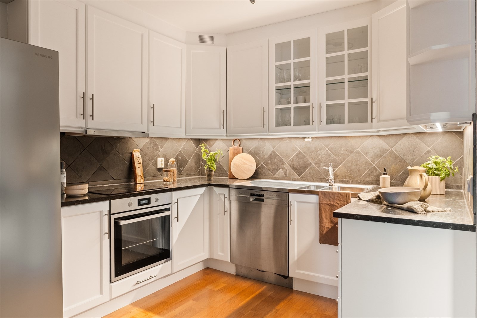 Innredning med profilerte fronter, laminat benkeplate og fliser på vegg. Skap fra gulv til tak gir god utnyttelse av plassen. Galleribilde