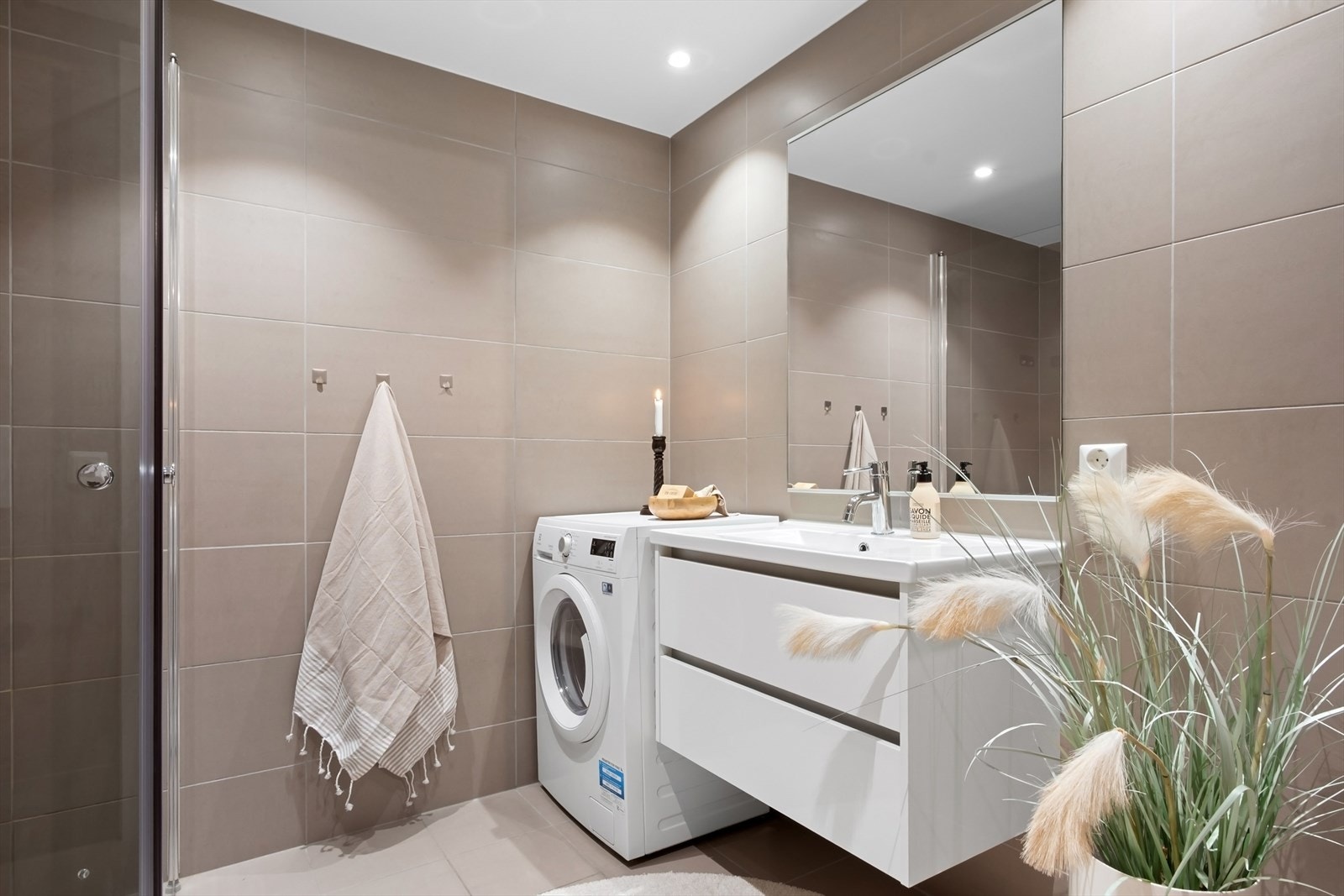 Badet har en god størrelse og fremstår romslig og praktisk, med opplegg for vaskemaskin. Galleribilde